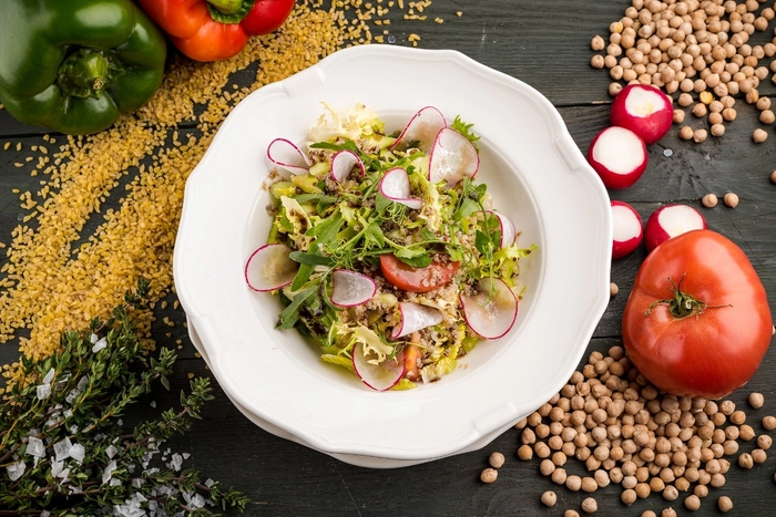 salata de post langa o rosie si ridiche pe o masa cu mai multe condimente