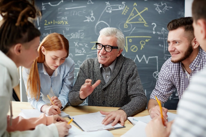 un profesor cu ochelari care le vorbește studenților