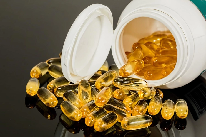 recipient din care au cazut mai multe capsule de omega pe o masa