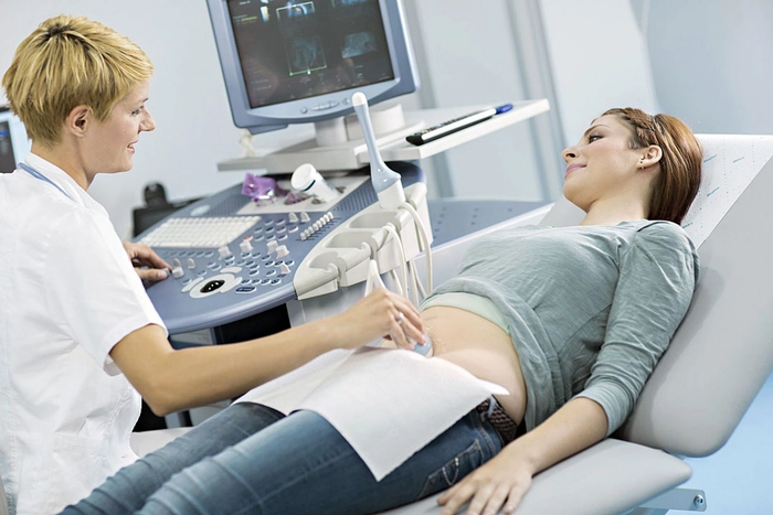 persoana care efectueaza o ultrasonografie unei femei