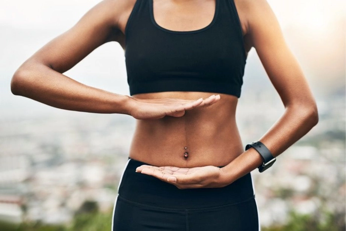 femeie care tine mainele la nivelul abdomenului in zona pancreasului