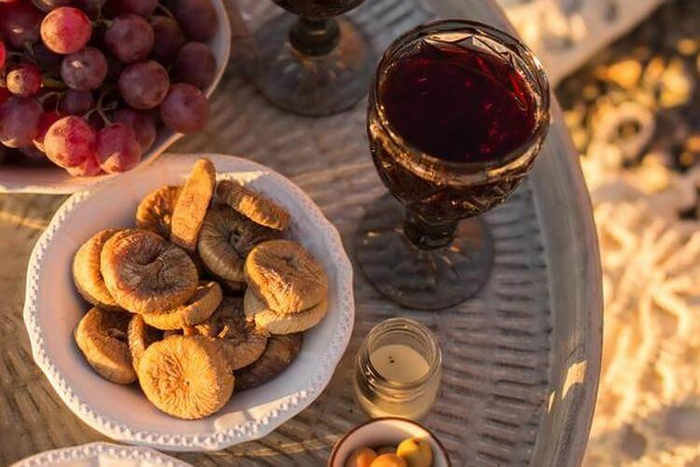 un pahar de vin langa smochine pe o masa