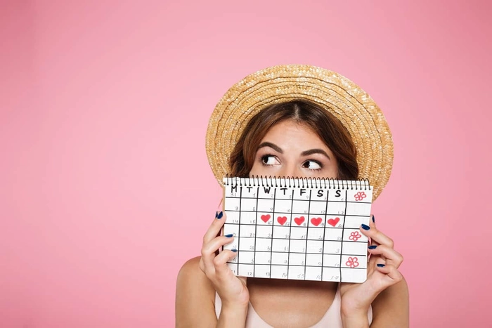femeie care tine un calendar in mana
