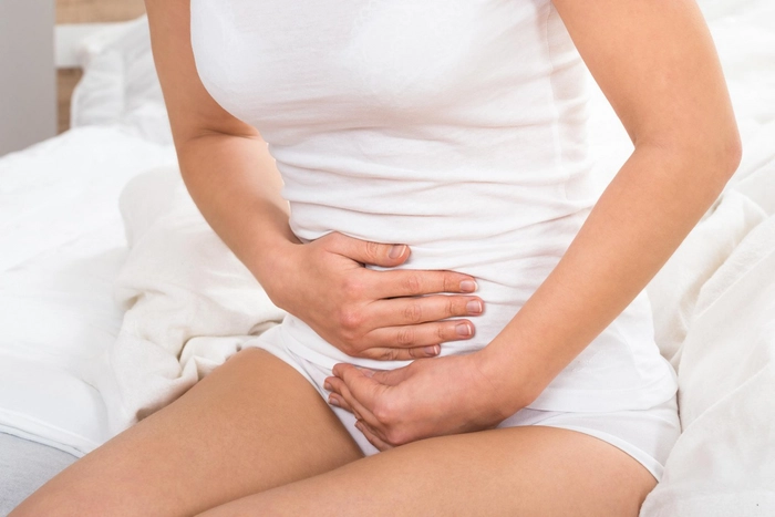 femeie care se tine de abdomen din cauza durerii