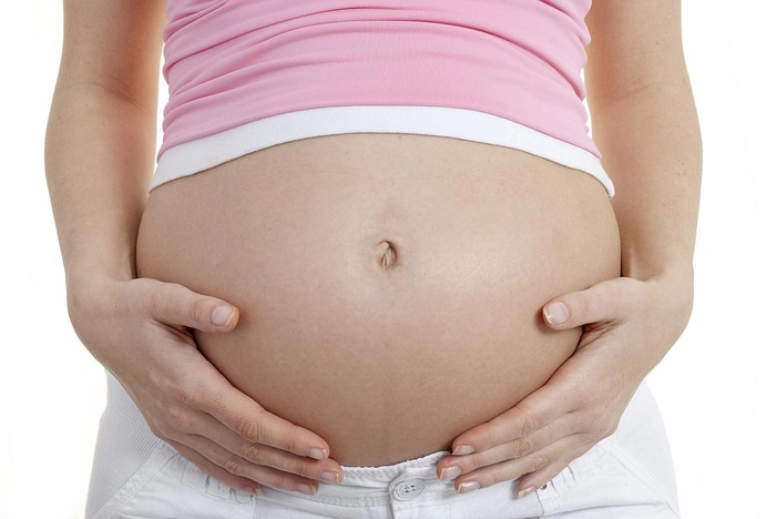 femeie insarcinata care se tine de burta