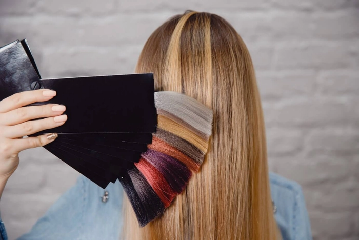femeie care isi alege nuanta de vopsea pentru o schimbare de look