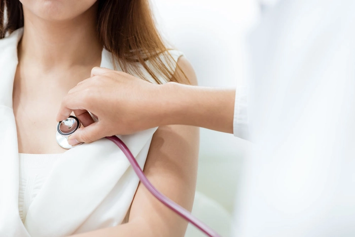 medic care asculta cu ajutorul unui stetoscop inima unei femei