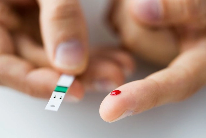 persoana care isi verifica nivelul de glicemie din sange
