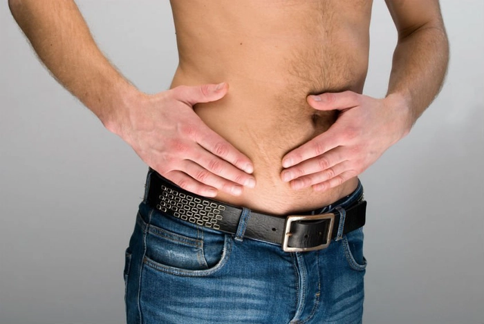 barbat care se tine de partea dreapta a abdomenului din cauza durerii