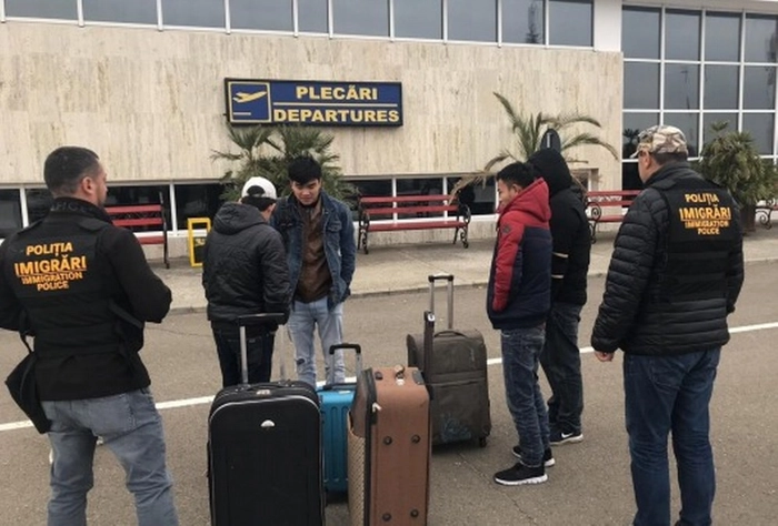 mai multe persoane cu valize langa un aeroport