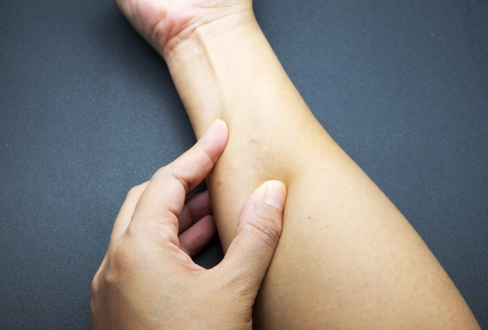 persoana care se tine de mana care sufera de noduli sub piele