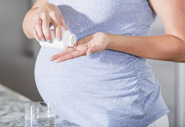femeie încsărcinată care ia medicamente