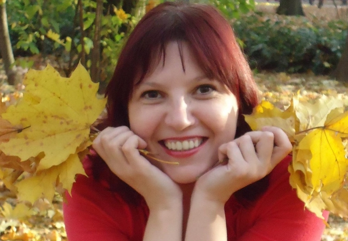 Daniela Simionovici cu frunze de toamna in mana si un zambet larg