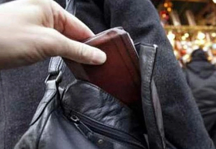 mana unui barbat ce fura un portofel dintr-o geanta