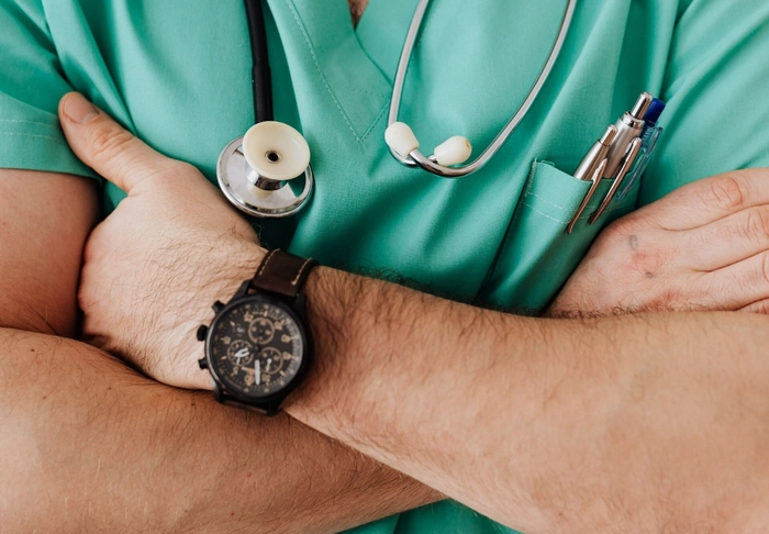 un medic care isi tine mainile incrucisate la piept