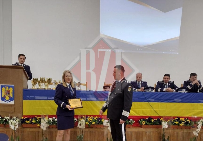 o politista tinand o diploma in mana langa Costel Gatlan si alti politisti pe fundal 