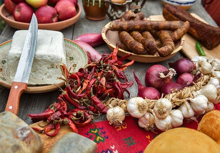 branza, usturoi si carnat pe o masa cu maasa in stil traditional