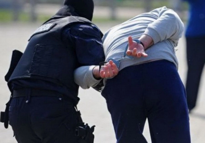un barbat tinut in catuse de un politist