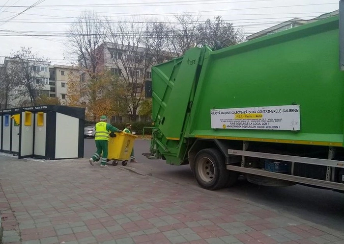 doua persoane cu un container langa o masina de salubrizare si o ghena