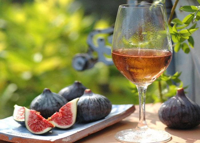 un pahar de vin langa smochine pe o masa