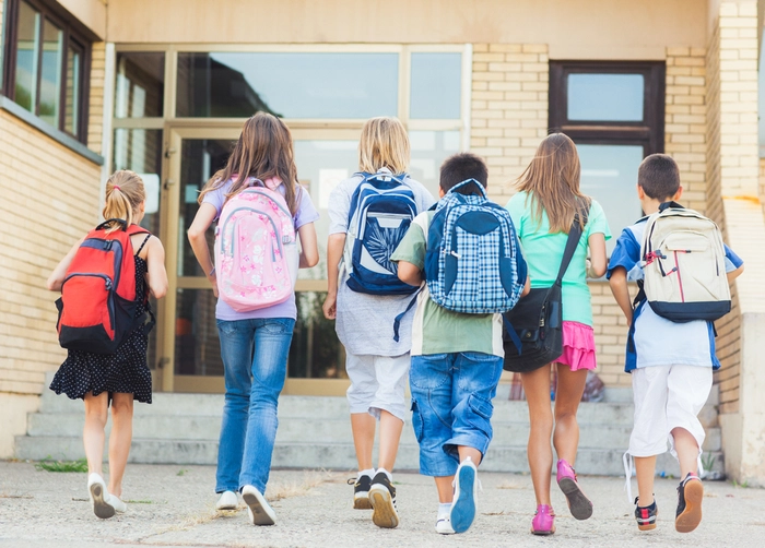  copii intorsi cu spatele care au ghiozdane in spate