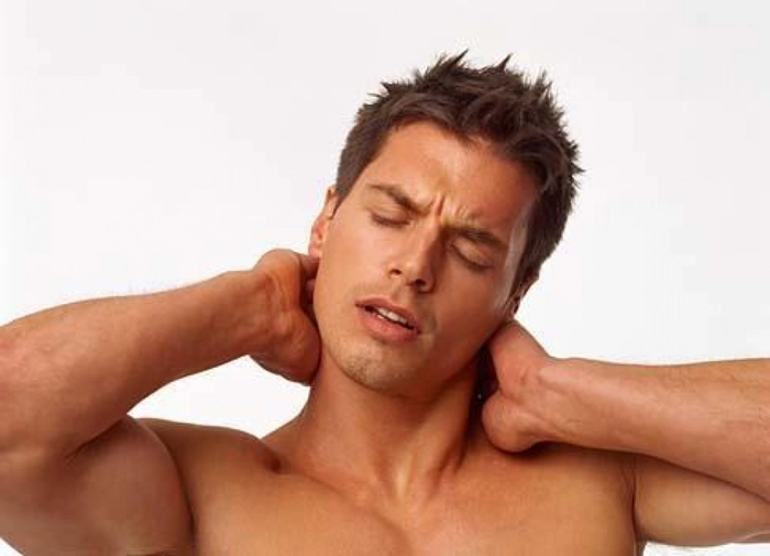 barbat care se tine de gat din cauza durerilor musculare