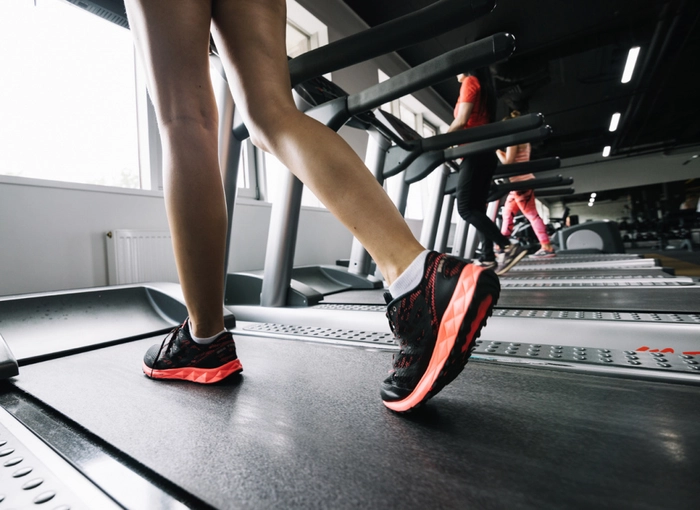 femeie care merge pe o banda intr-o sala de sport