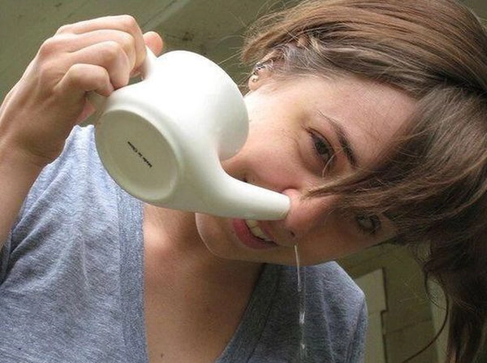 persoana care foloseste un ibric cu apa sarata pentru a ameliora sinuzita