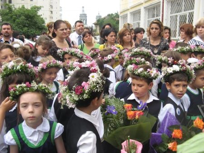 un  grup de elevi cu coronițe care iau parte la premiere