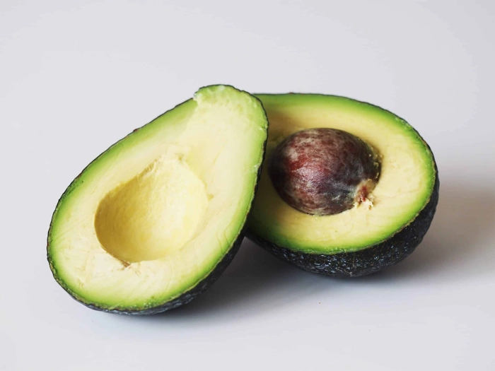 un avocado taiat in jumatate pe o masa