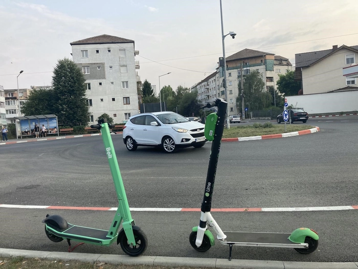 doua trotinete electrice, un suv alb si mai multe blocuri