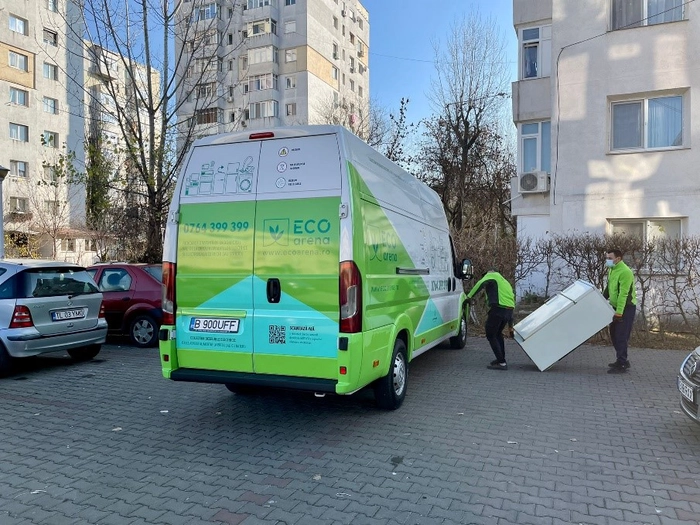 2 persoane care incarca un frigider intr-o masina
