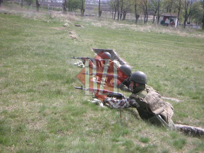 militari care trag cu arma pe camp