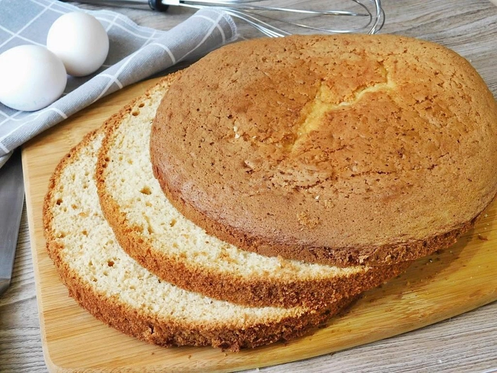 blat pentru tort langa mai multe oua si un prosop pe un suport de lemn