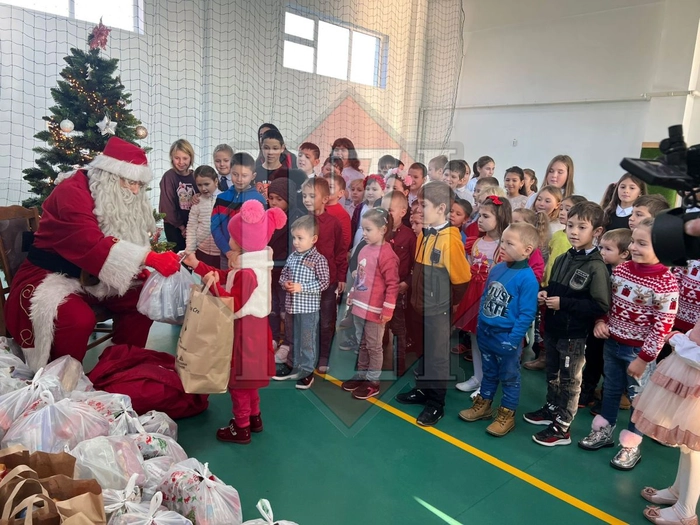  o poză cu copiii, care au primit cadouri și i-au pregătit niște cântece speciale lui Moș Crăciun