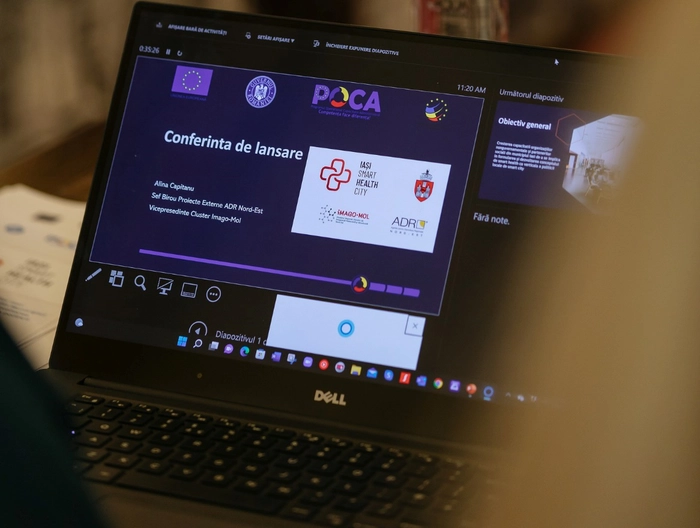 o imagine cu un laptop cu afisul conferintei