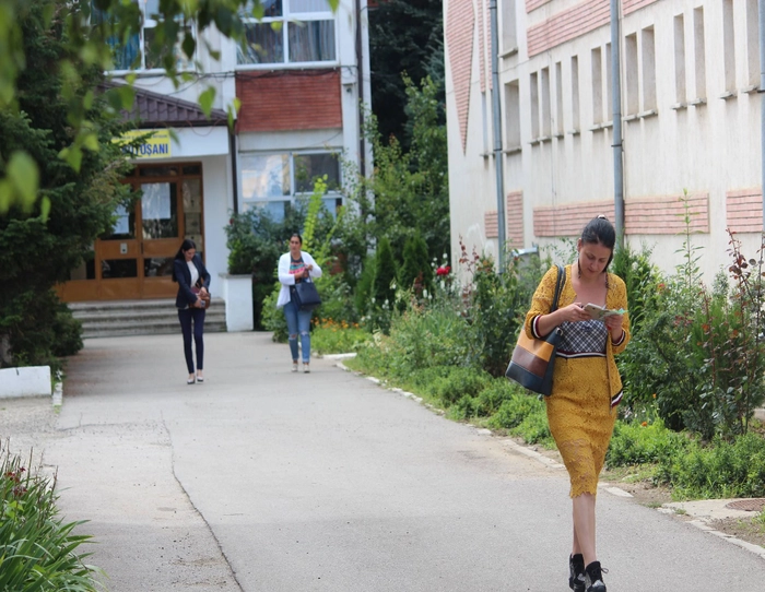Femeie citind in fata unei cladiri