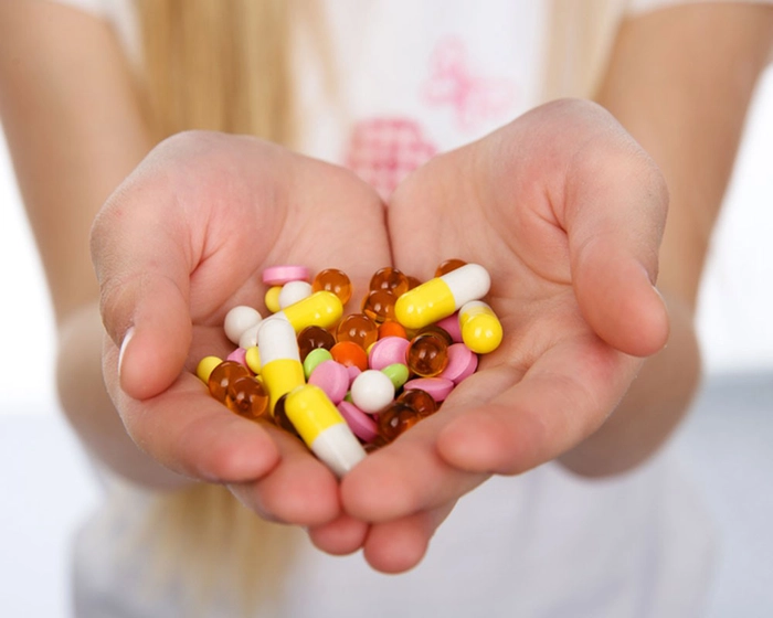 femeie care tine mai multe antibiotice in mana
