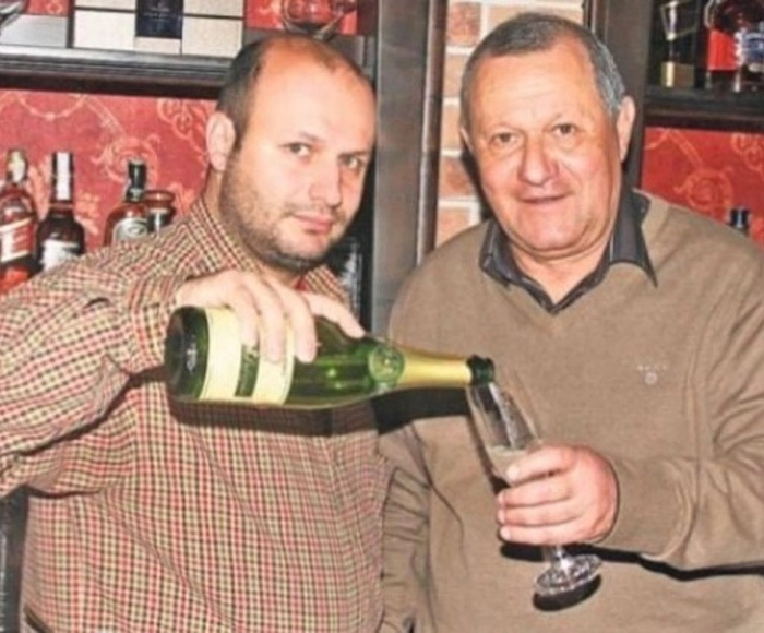 Crtistian Tantareanu cu un pahar in mana alaturi de fiul sau care toarna sampanie in pahar