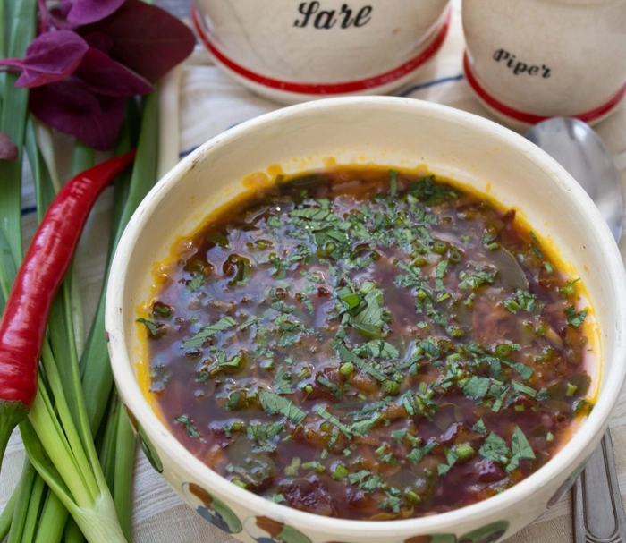 un bol cu ciorba de loboda langa mai multe ingrediente 