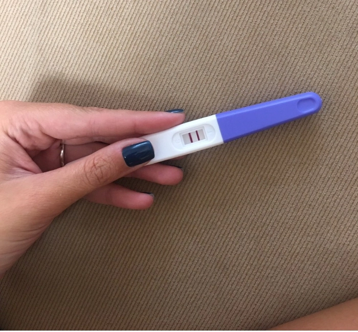 femeie care tine in mana un test de sarcoma pozitiv