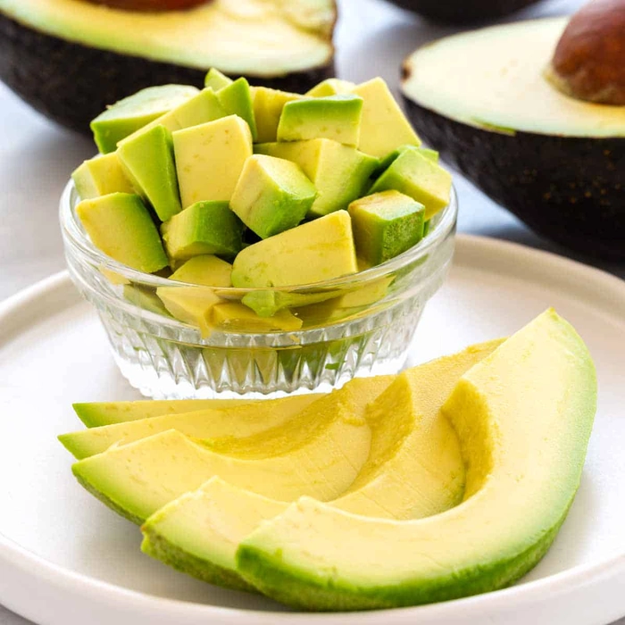 un bol cu avocado taiat pe o farfurie cu avocado taiat fasii