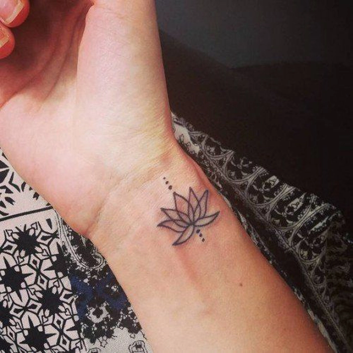 floare de lotus tatuata pe mana unei persoane 