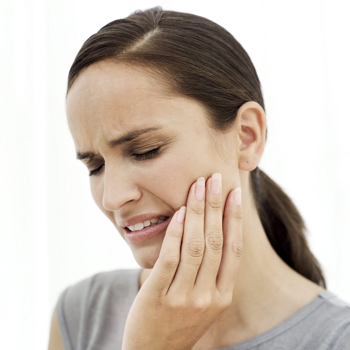 persoana care se tine cu mana de maxilar, acuză dureri dentare