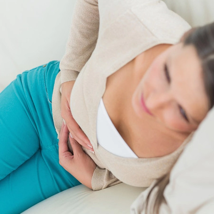 femeie care se tine de abdomen din cauza vezicii urinare