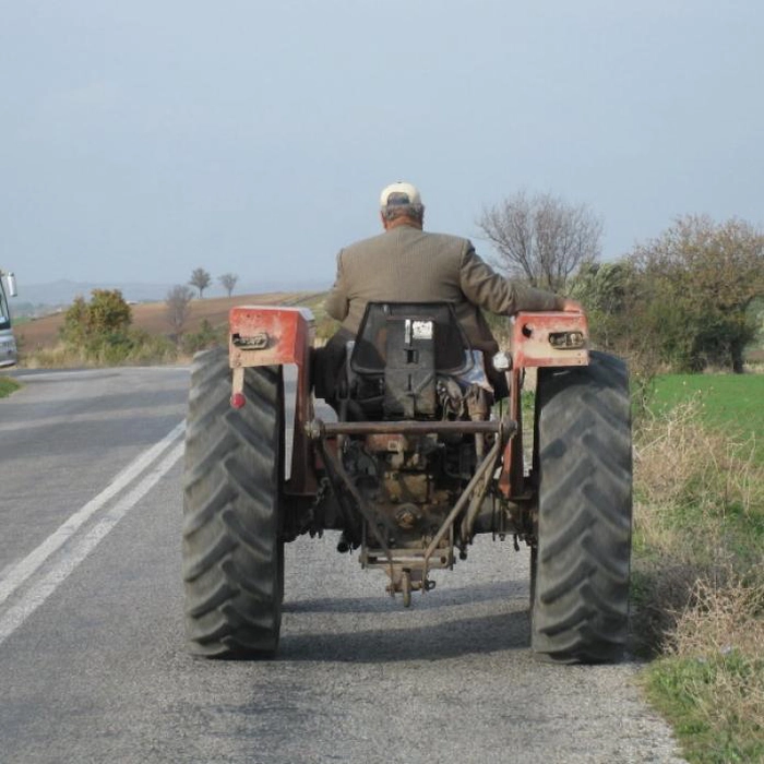 o persoana care merge cu un tractor pe sosea