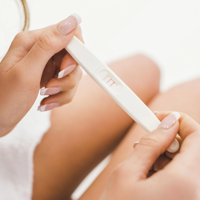 femeie care tine in mana un test de sarcina