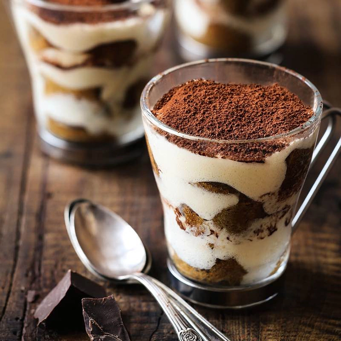 prajitura tiramisu intr-o cana pe o masa langa o lingurita