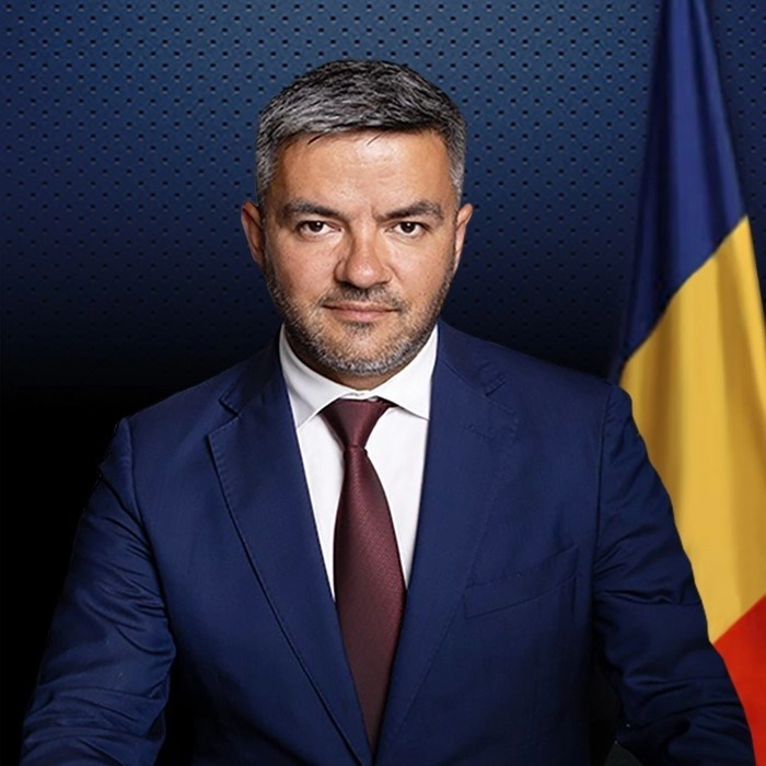 Ciprian Grosu la costum pe fundal cu steagul Romaniei