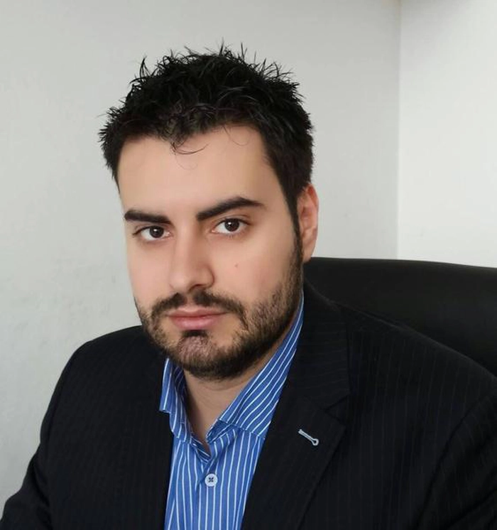 Andrei Tabarcea la costum negru si camasa albastra cu dungi albe